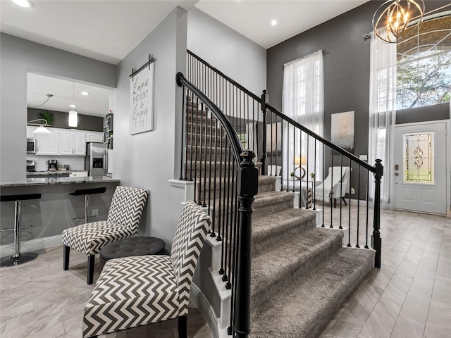 stairs with a chandelier and recessed lighting
