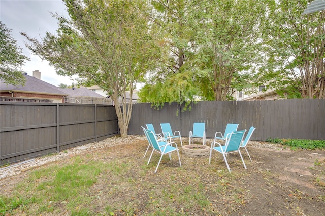 fenced backyard featuring a fire pit