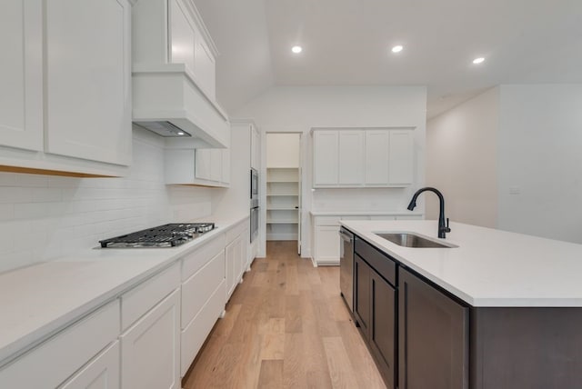 636 Caprice Blf, Fate, TX 75189 - kitchen with stainless steel appliances, a sink, premium range hood, tasteful backsplash, and white cabinetry