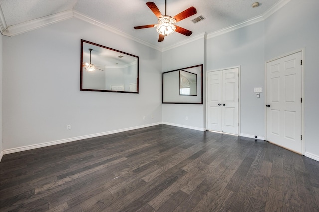 spare room with ceiling fan, dark wood finished floors, baseboards, vaulted ceiling, and crown molding