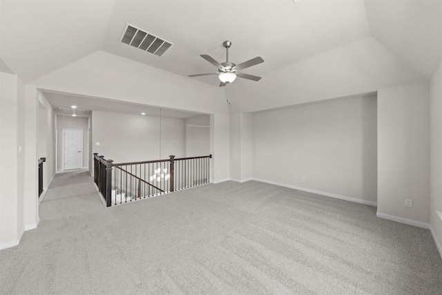 carpeted empty room featuring vaulted ceiling, a ceiling fan, visible vents, and baseboards