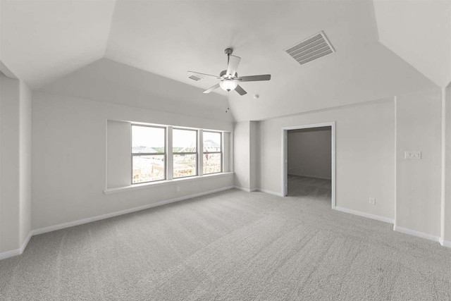 interior space with vaulted ceiling, carpet flooring, visible vents, and baseboards