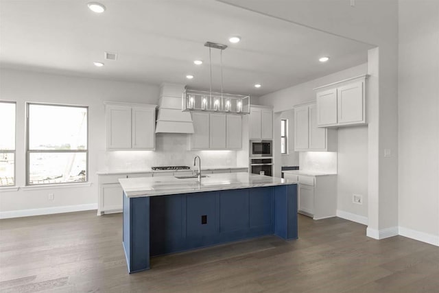 kitchen with white cabinets, dark wood-style flooring, appliances with stainless steel finishes, and premium range hood