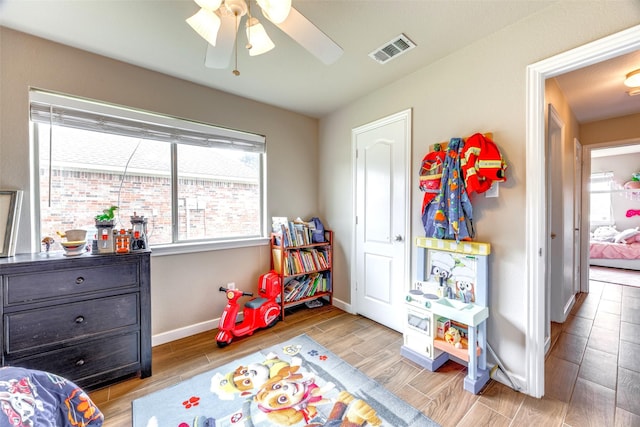 bedroom with visible vents, a ceiling fan, baseboards, and wood finished floors