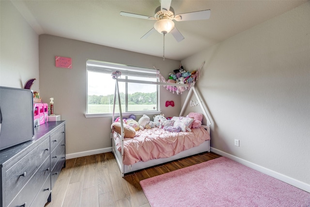 bedroom featuring baseboards, ceiling fan, and light wood-style flooring