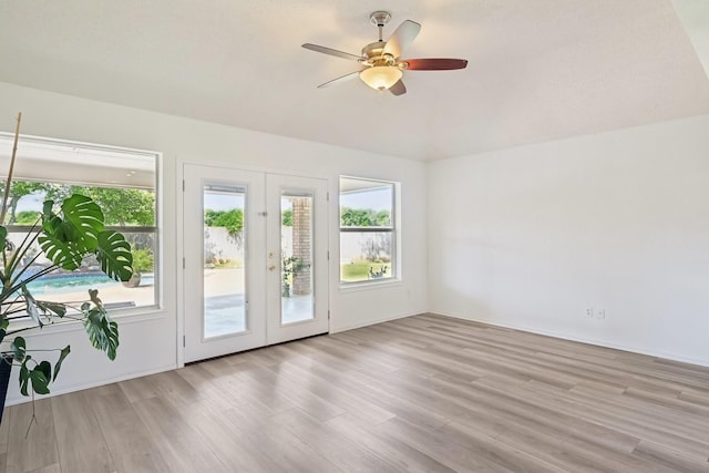 interior space featuring vaulted ceiling, light wood-style flooring, and a ceiling fan