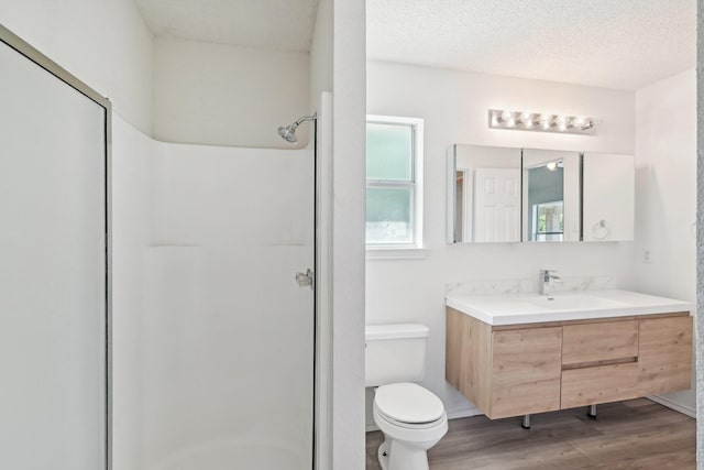 full bath featuring wood finished floors, an enclosed shower, toilet, and vanity