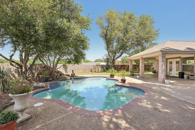 view of swimming pool with french doors, a fenced in pool, a patio, and a fenced backyard