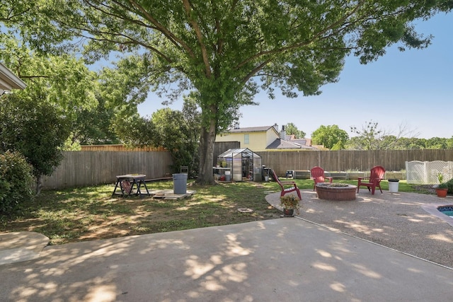 view of yard with a fire pit, a patio, and a fenced backyard