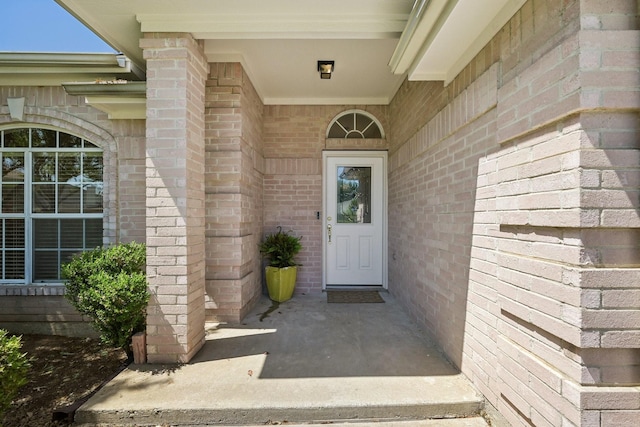 entrance to property featuring brick siding