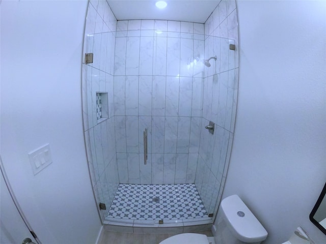 bathroom featuring a shower stall and toilet