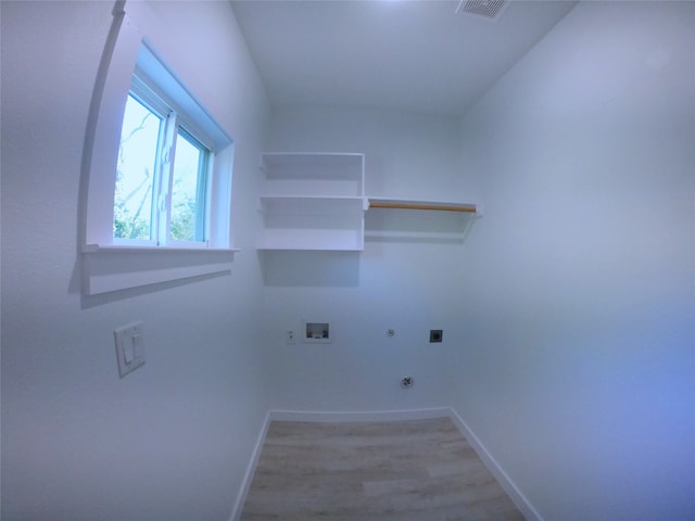 laundry room with light wood-type flooring, baseboards, electric dryer hookup, gas dryer hookup, and laundry area