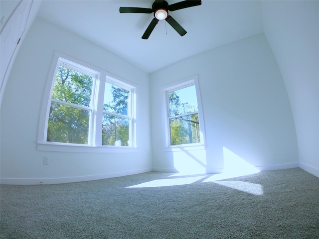 carpeted spare room featuring baseboards and a ceiling fan