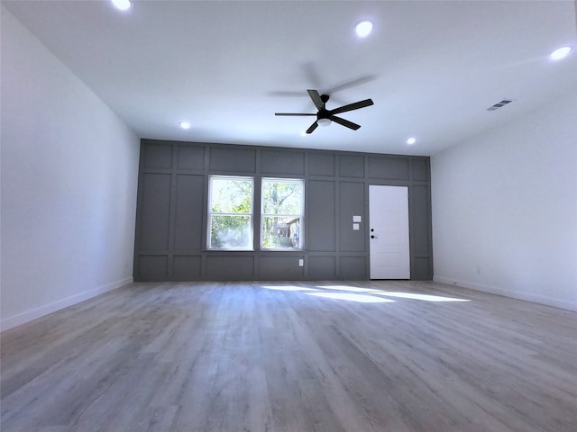 unfurnished living room featuring recessed lighting, wood finished floors, visible vents, a ceiling fan, and a decorative wall