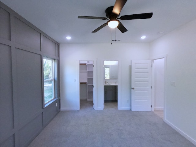unfurnished bedroom featuring light carpet, visible vents, a spacious closet, and recessed lighting
