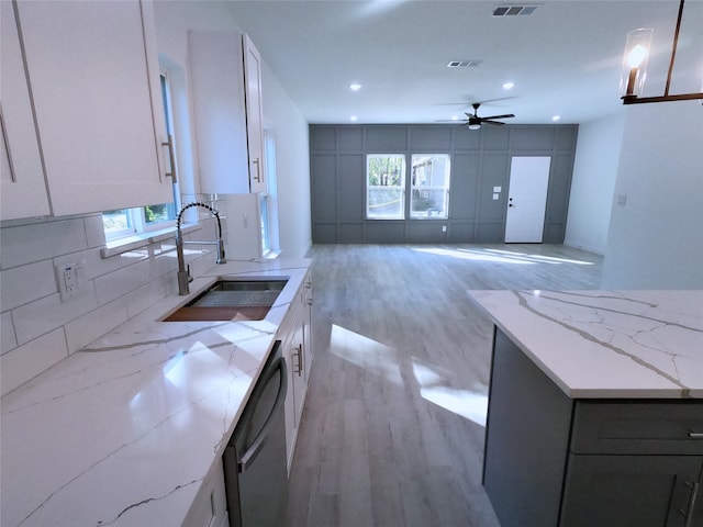 kitchen with light wood-type flooring, dishwasher, plenty of natural light, and a sink