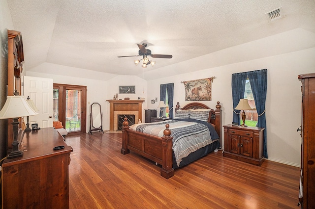5625 Guadalajara Dr, North Richland Hills, TX 76180 - bedroom featuring wood finished floors, baseboards, a tiled fireplace, a textured ceiling, and a ceiling fan