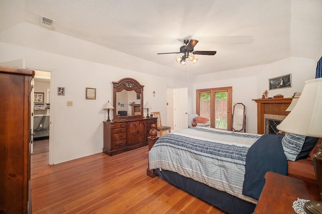 5625 Guadalajara Dr, North Richland Hills, TX 76180 - bedroom with wood finished floors, baseboards, a textured ceiling, a ceiling fan, and a fireplace