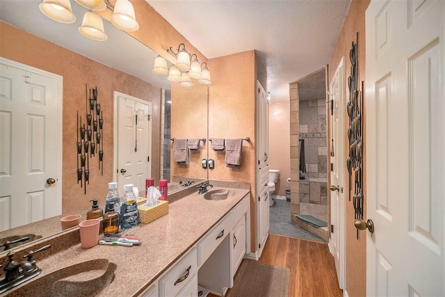 5625 Guadalajara Dr, North Richland Hills, TX 76180 - bathroom featuring toilet, a tile shower, double vanity, and wood finished floors