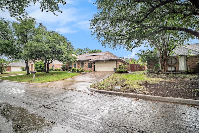 5625 Guadalajara Dr, North Richland Hills, TX 76180 - view of front of house with an attached garage, roof mounted solar panels, and driveway