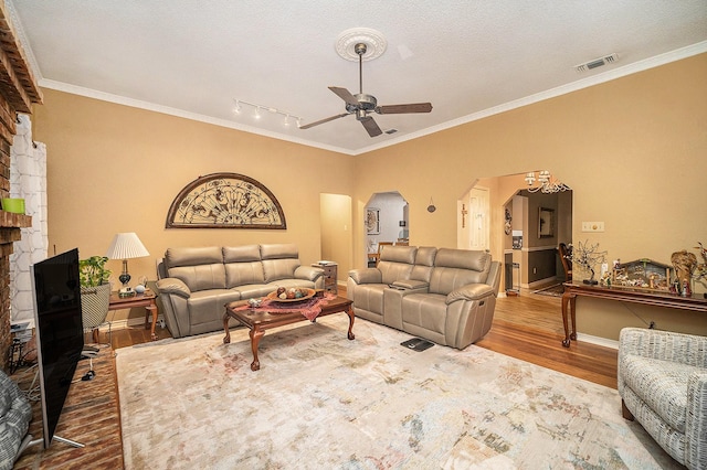 5625 Guadalajara Dr, North Richland Hills, TX 76180 - living area with wood finished floors, ceiling fan, arched walkways, rail lighting, and crown molding