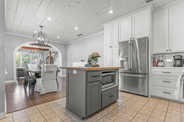 kitchen featuring arched walkways, stainless steel appliances, a notable chandelier, gray cabinetry, and recessed lighting