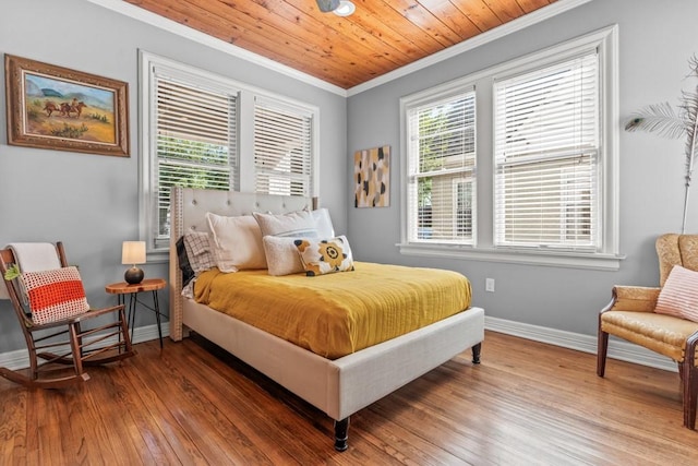 bedroom with wood finished floors, baseboards, and ornamental molding