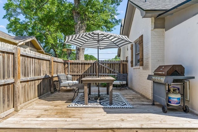 deck with area for grilling and a fenced backyard