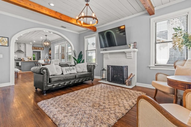 living room with beamed ceiling, a wealth of natural light, and a chandelier