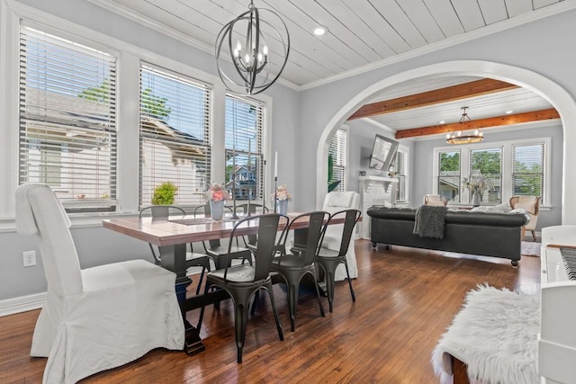 dining area featuring arched walkways, an inviting chandelier, dark wood-type flooring, and crown molding