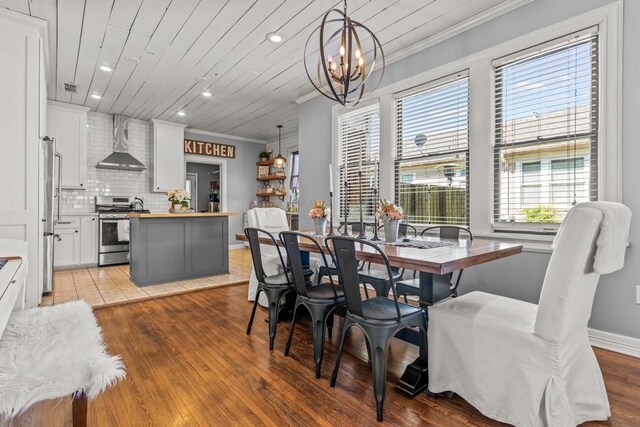 dining space featuring recessed lighting, light wood-style floors, crown molding, and a notable chandelier