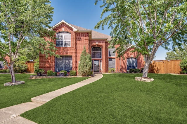 3932 Harrison Ct, Carrollton, TX 75010 - traditional-style house featuring brick siding, roof with shingles, a front lawn, and fence