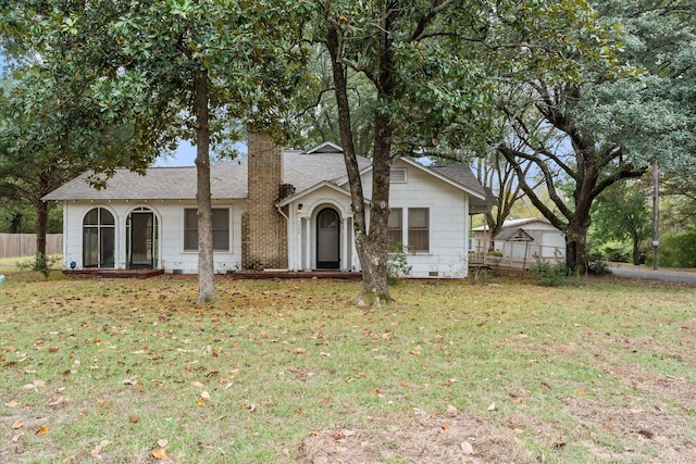 1302 E 1st St, Mount Pleasant, TX 75455 - ranch-style house with a front yard, roof with shingles, a chimney, and fence