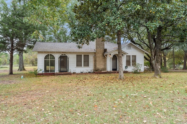 1302 E 1st St, Mount Pleasant, TX 75455 - view of front of property with a shingled roof, a chimney, and a front yard