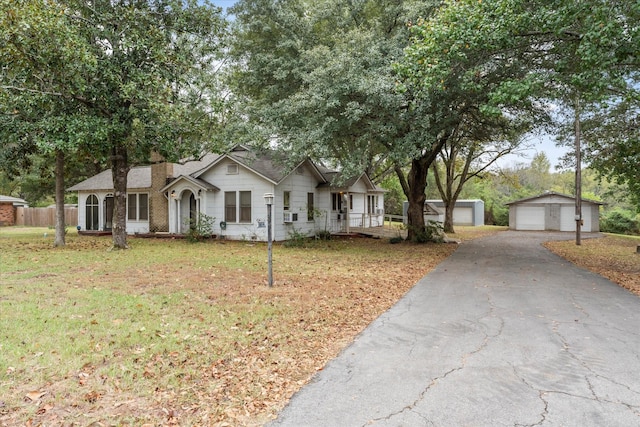 1302 E 1st St, Mount Pleasant, TX 75455 - single story home with a front lawn, an outdoor structure, fence, a porch, and a garage