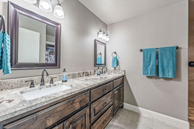 5003 Frio Dr, Granbury, TX 76048 - bathroom with double vanity, baseboards, and tile patterned floors