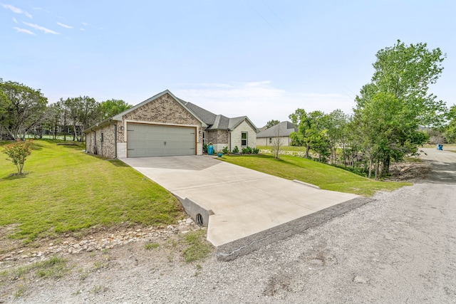5003 Frio Dr, Granbury, TX 76048 - view of front of home with a front lawn, concrete driveway, brick siding, and a garage
