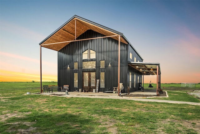 back of house featuring board and batten siding and a yard