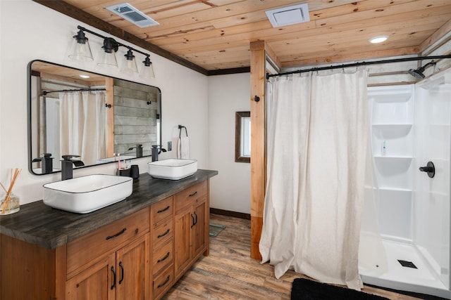 bathroom with wood finished floors, wooden ceiling, visible vents, and a sink