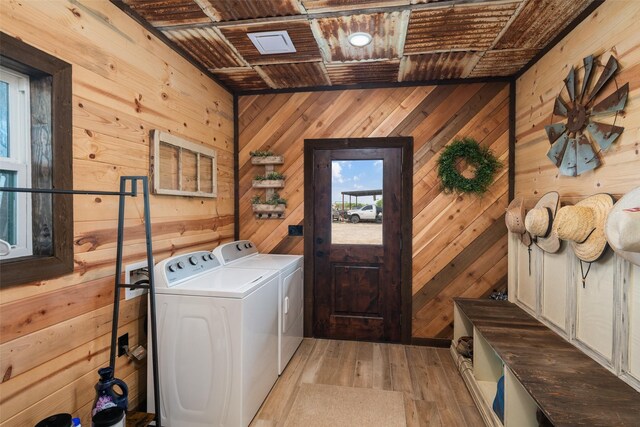 laundry room with wood ceiling, separate washer and dryer, wood walls, and light wood-style flooring