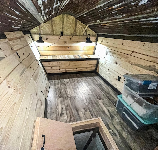 bonus room featuring wood-type flooring, wooden walls, and lofted ceiling