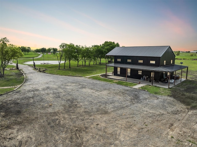 view of front of house featuring board and batten siding, a standing seam roof, a front yard, and metal roof