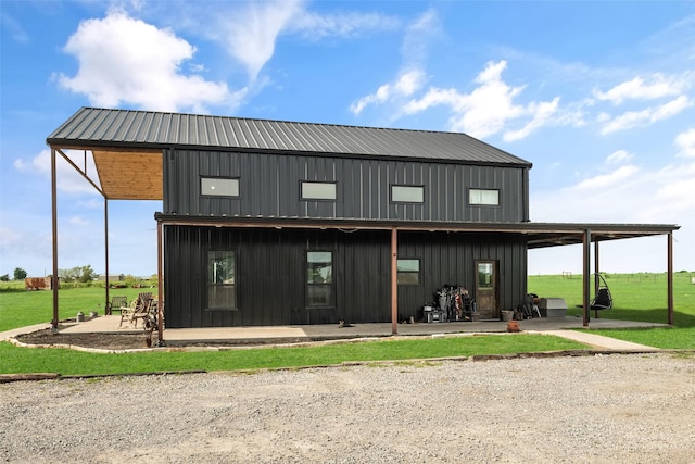 exterior space featuring a lawn, a patio area, and metal roof