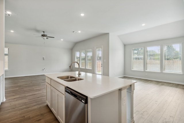 kitchen with lofted ceiling, open floor plan, stainless steel dishwasher, and a sink