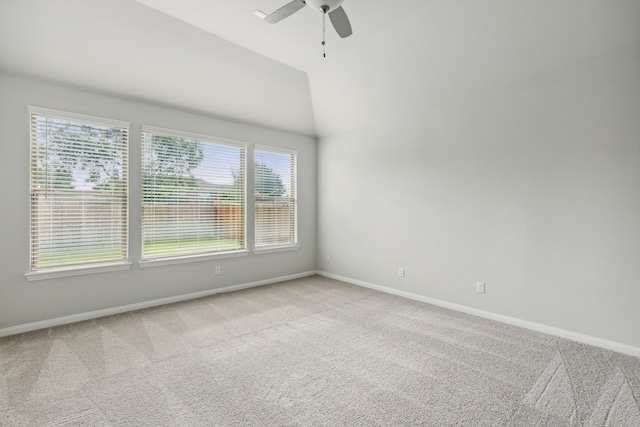 carpeted spare room with ceiling fan, baseboards, and vaulted ceiling