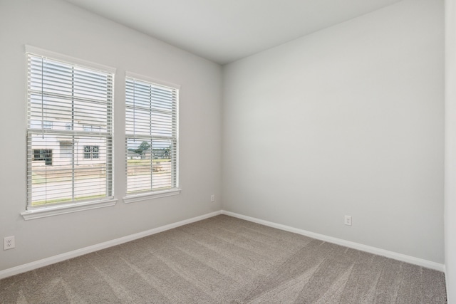 carpeted spare room featuring baseboards