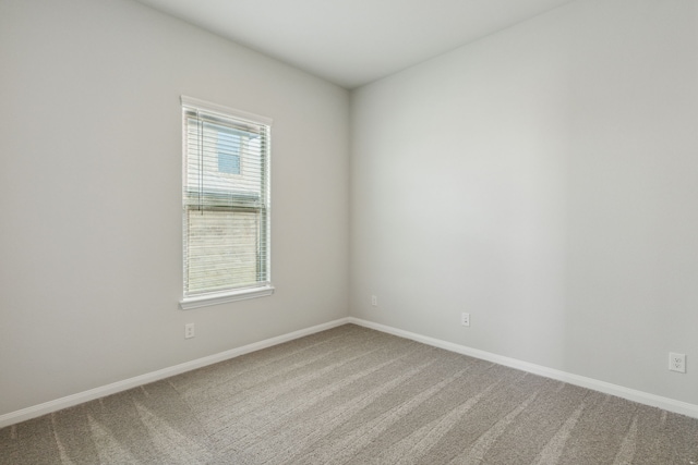 carpeted spare room with baseboards