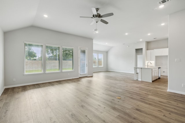 unfurnished living room with lofted ceiling, a ceiling fan, and light wood-style flooring