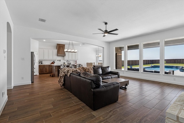 12816 Rocky Top Rd, Godley, TX 76044 - living room featuring ceiling fan with notable chandelier, visible vents, arched walkways, and dark wood-style floors