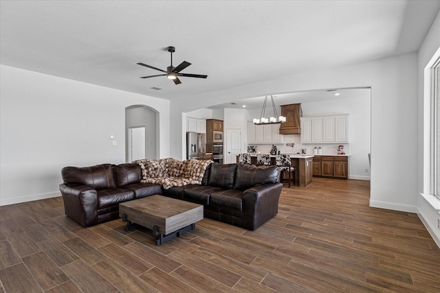 12816 Rocky Top Rd, Godley, TX 76044 - living area with arched walkways, baseboards, dark wood-style flooring, and ceiling fan with notable chandelier
